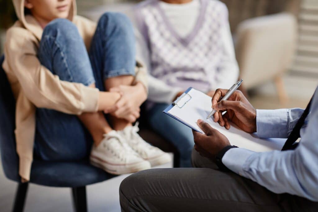 Two teens sit during a therapy session.