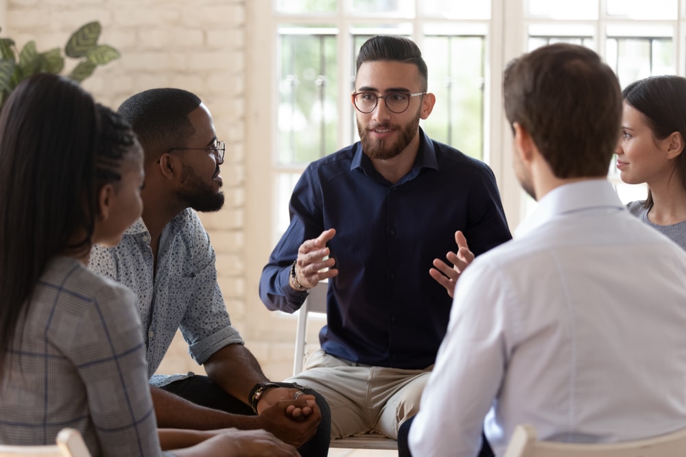 A man leads a group therapy session.