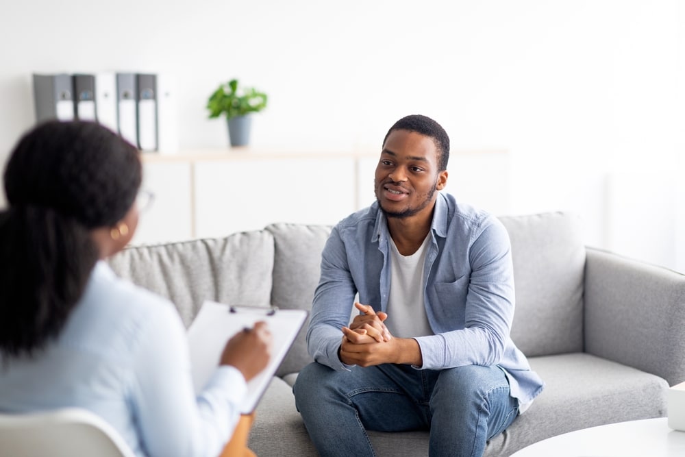 A man talks with a psychologist during a therapy session.
