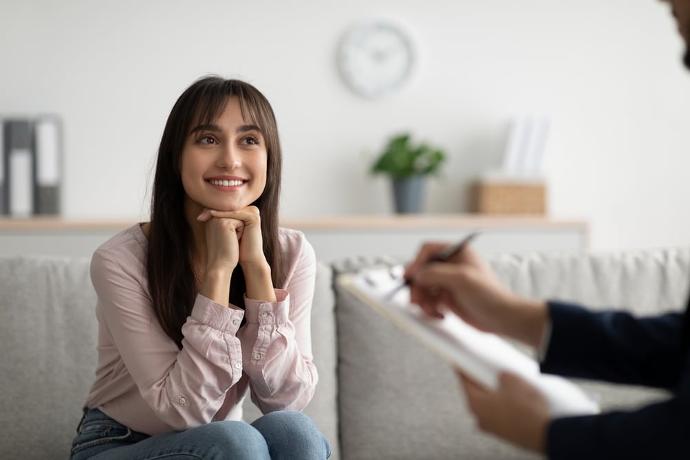 A woman listens to her therapist during a session.