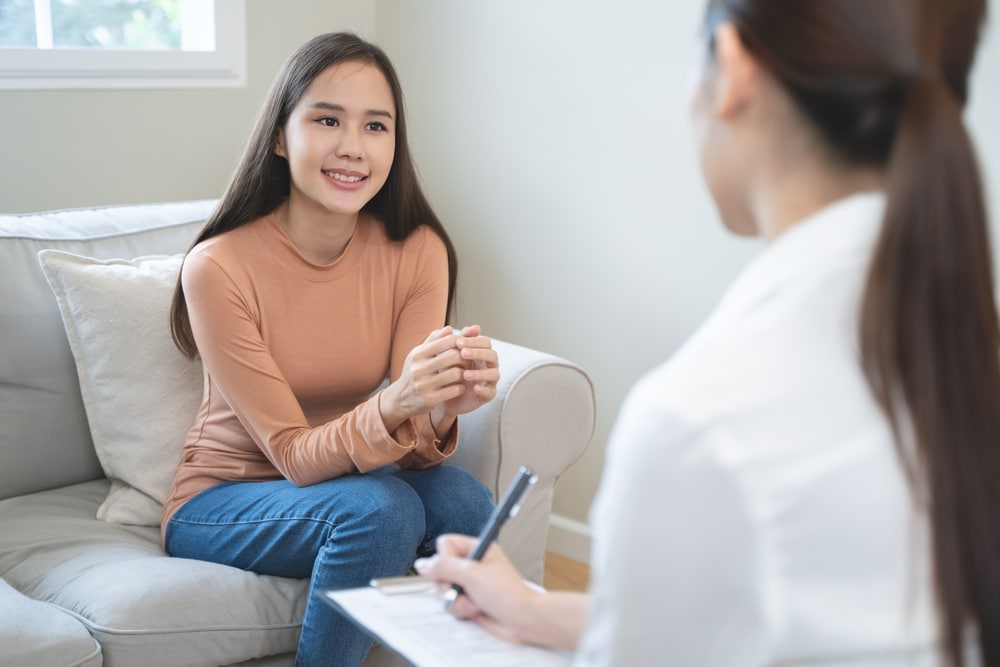 A woman speaks to a therapist during a session.