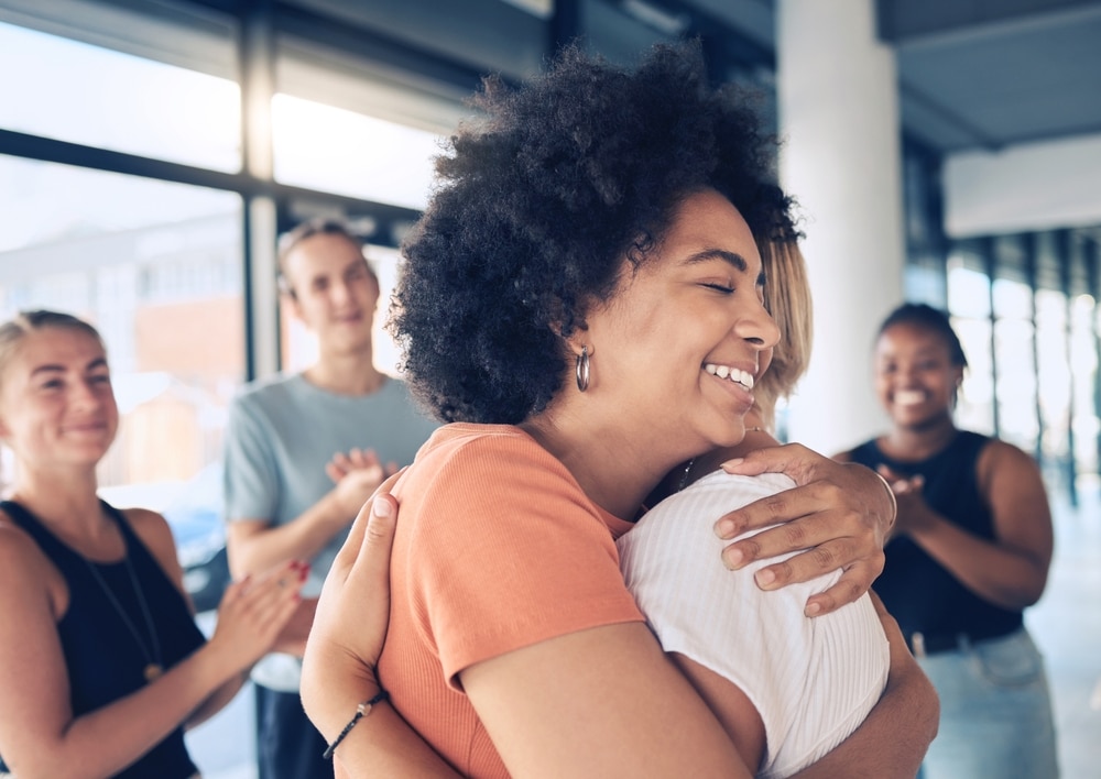 Two happy woman hug.