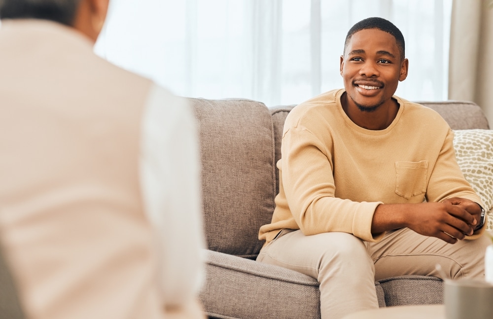 A man smiles during a therapy session.