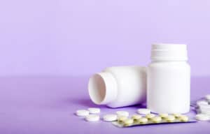 Comparing Tramadol vs Oxycodone: Two bottles of pills and a blister pack of pills in front of a white background.