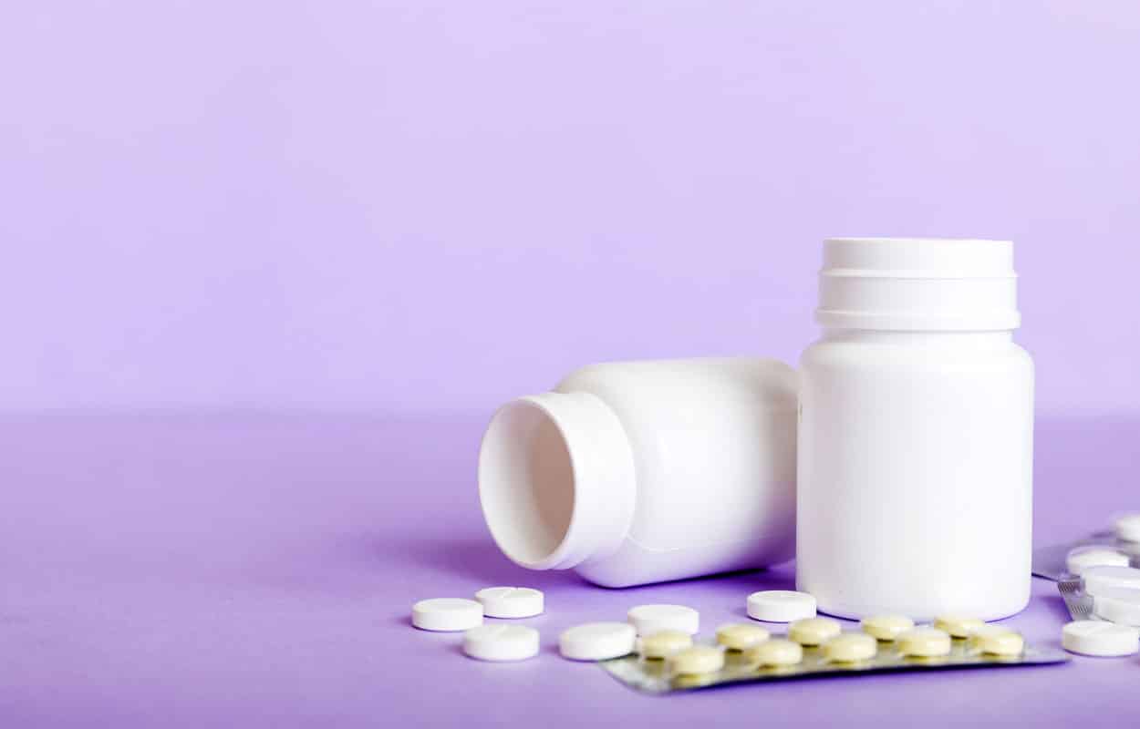Comparing Tramadol vs Oxycodone: Two bottles of pills and a blister pack of pills in front of a white background.