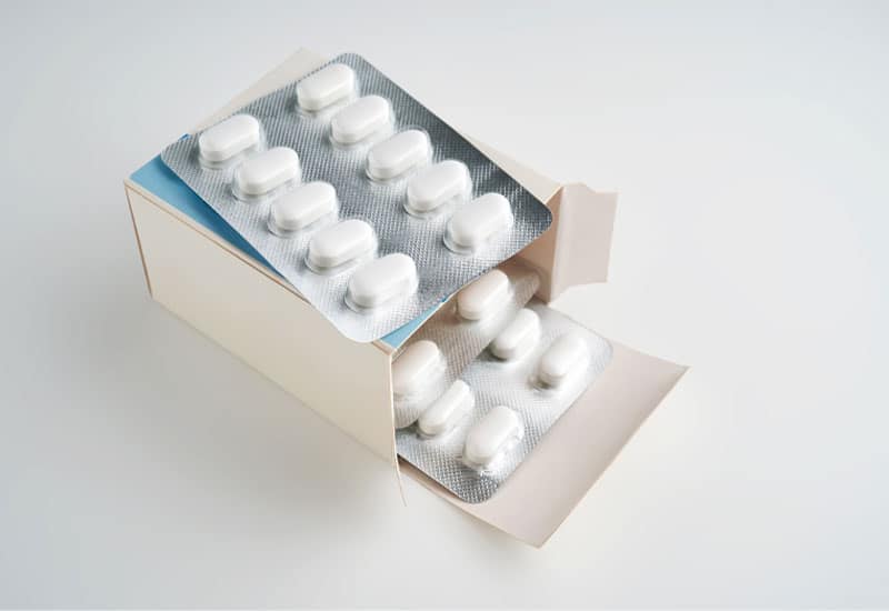 Is Tramadol Habit-Forming? A blister pack of white pills on a box of additional blister packs.