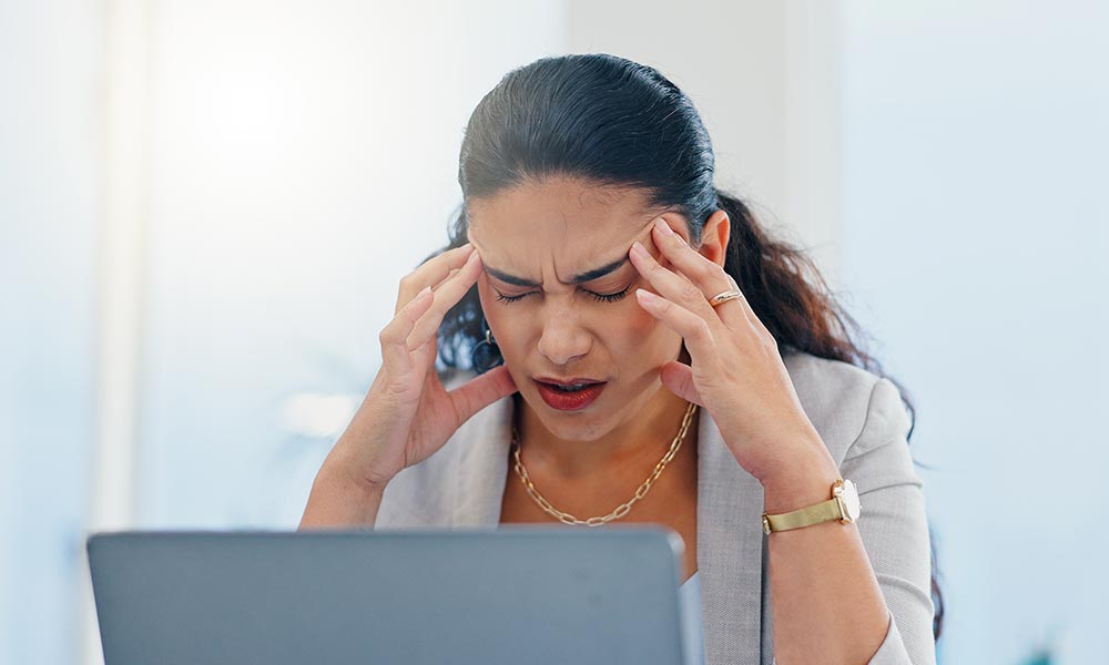 woman-headache-and-pain-with-laptop-in-office